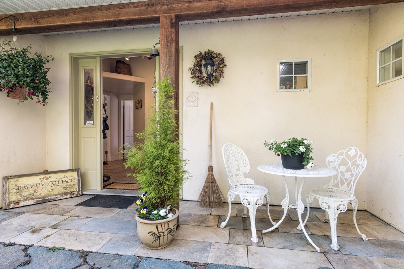 The cottage entrance, with a small table and chairs on the stone patio