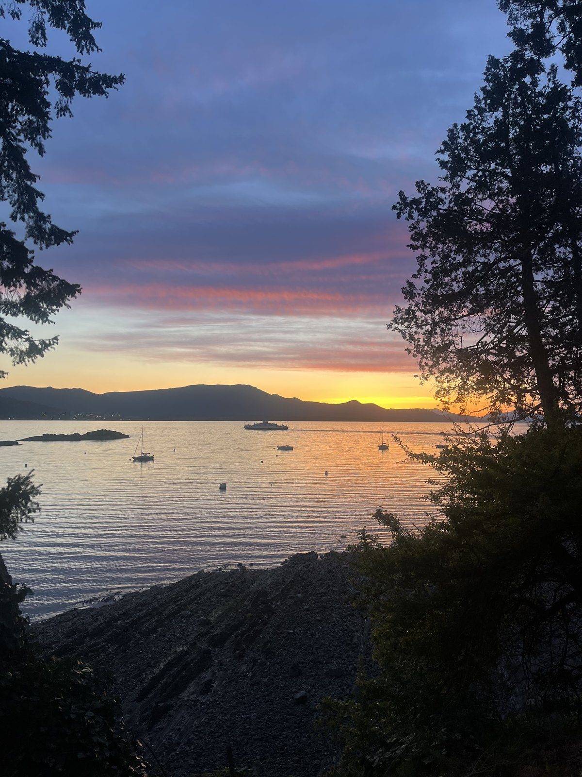 Sunset over Vesuvius Bay, with sailboats at anchor and the Crofton ferry crossing